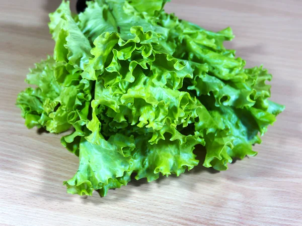 Green leafy vegetables. Salad is located on the cutting table.