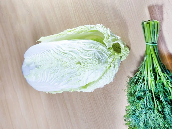 Green leafy vegetables. Peking cabbage and dill on a cutting table.