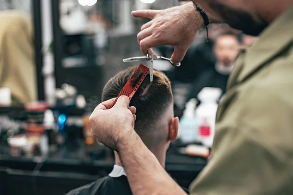 Kendine güvenen adam güzellik salonunda oturuyor. Erkek saç kesimi. Yumuşak odak.