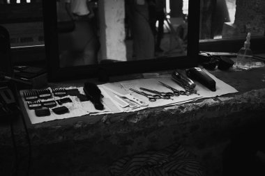 Aynanın önünde masaüstünde bir Kuaför araçları. Siyah ve beyaz fotoğraf Kuaför araçları. Fotoğraf karanlık anahtar.