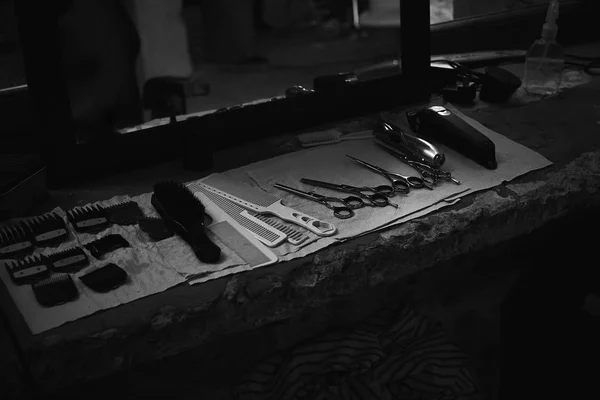 镜子前的桌面上的理发师的工具 美发工具的黑白照片 相片在黑暗的钥匙 — 图库照片