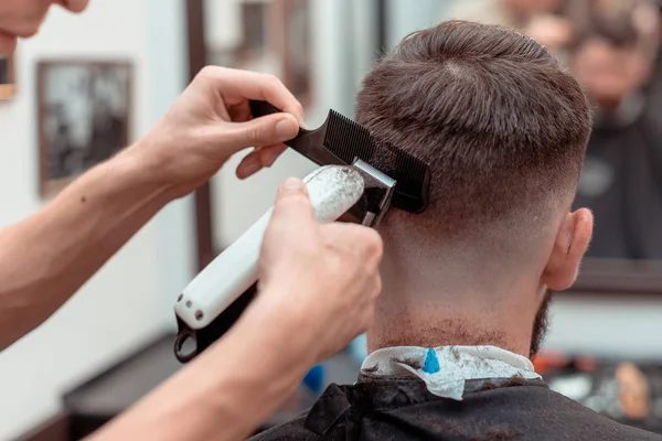 A man is hanging around in a beauty salon. Haircut and styling in barbershop. Men's care for beard and hair.