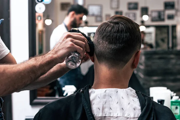 Um homem está num salão de beleza. Corte de cabelo e styling na barbearia. Homens cuidados com a barba e cabelo . — Fotografia de Stock