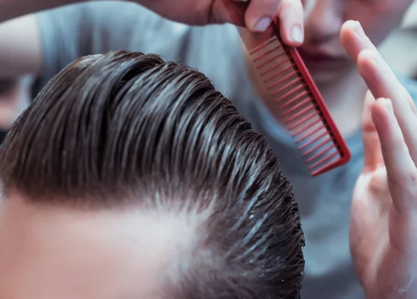 Um homem está num salão de beleza. Corte de cabelo e styling na barbearia. Homens cuidados com a barba e cabelo . — Fotografia de Stock