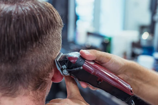 Ein Mann hängt in einem Schönheitssalon herum. Haarschnitt und Styling im Friseursalon. Männerpflege für Bart und Haare. — Stockfoto