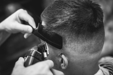 Kendine güvenen adam güzellik salonunda oturuyor. Erkek saç kesimi. Yumuşak odak.