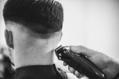 Erkek saç kesimi içinde güzellik salonu. Kuaför saç tıraşına istemciye yapar. Bir saç kesimi için hazırlanıyor.