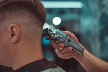 Berber şık bir erkek saç modeli yapar.