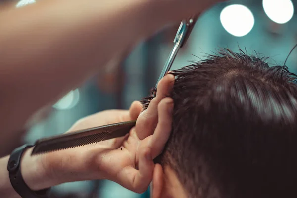 Barbeiro faz um penteado masculino elegante . — Fotografia de Stock