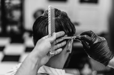 Erkek saç kesimi. Makasla saç kesimi. Siyah beyaz fotoğraf.