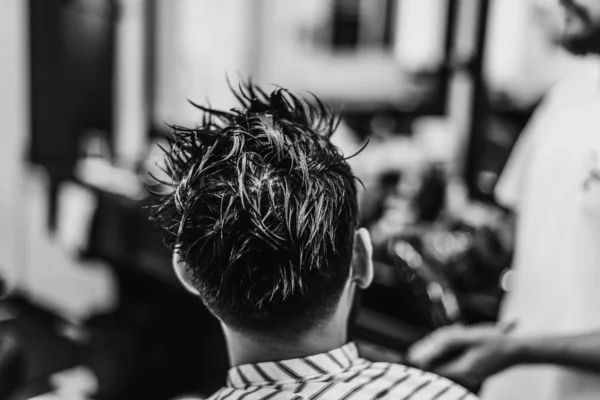 Une coupe de cheveux d'homme. Coupe de cheveux avec des ciseaux. Photo noir et blanc . — Photo