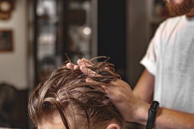 Berber saç şekillendirme yapar. Erkek Saç Bakımı.