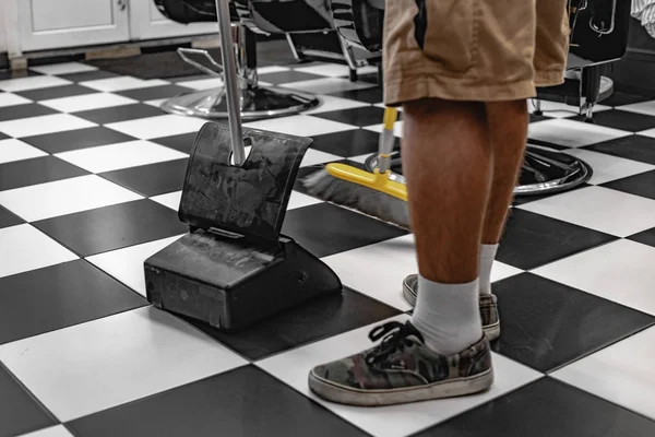 Fryzjer czyści miejsce pracy po strzyżenie. — Zdjęcie stockowe