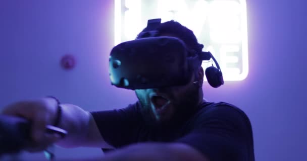 Hombre jugando un juego de disparos con un casco de realidad virtual. — Vídeo de stock