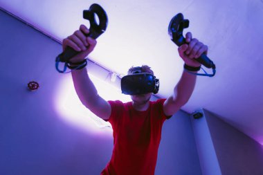 VR E-Sports. Adam oyun neon odasında online tetikçi oynuyor..