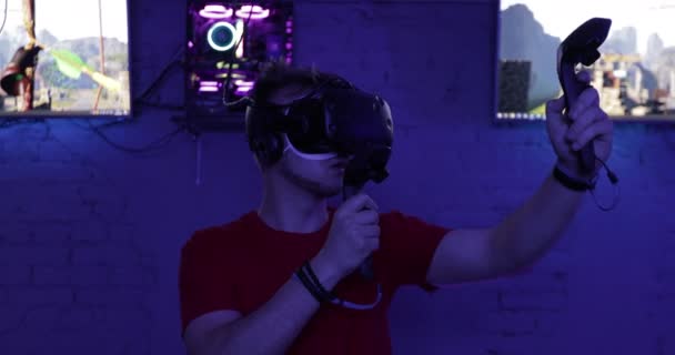 El tipo dispara un arco en una simulación de computadora. Habitación Neon VR . — Vídeos de Stock