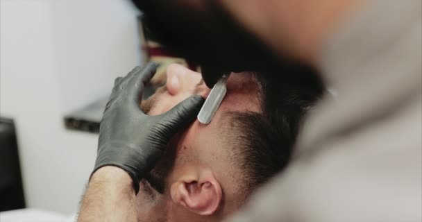 Peluquero hace el trabajo de cortar y ribetear la barba . — Vídeo de stock