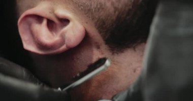 Berber dükkanında erkek tıraşı. Tehlikeli bir jiletle tıraş olmak..