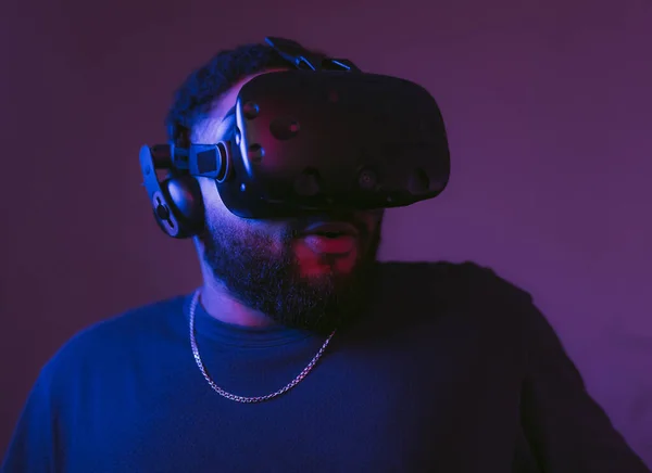Człowiek w cyberhełmie. Nowe gry VR w neonowym pokoju. — Zdjęcie stockowe