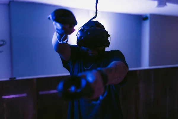 Seorang pria dengan helm cyber. Permainan VR baru di ruang neon. — Stok Foto