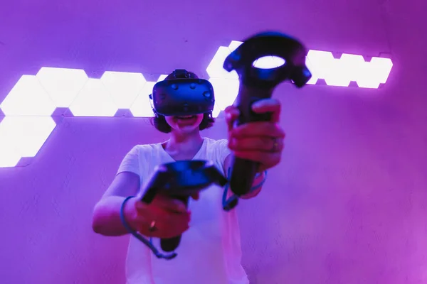 Dziewczyna grająca w gry w okulary VR. Neonowy fioletowy pokój. Cyberpunk gry. — Zdjęcie stockowe