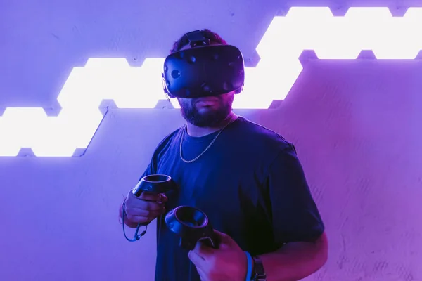Virtuális valóság egy neon lila szobában. Férfi VR szemüvegben. — Stock Fotó