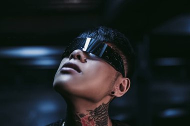 Siber punk. Fütürist gözlüklü bir adam gece gökyüzüne bakıyor. Gece neon şehri.