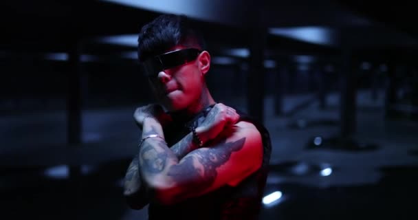 Homme tatoué avec des lunettes élégantes. Il a croisé les bras. Ville de nuit. — Video