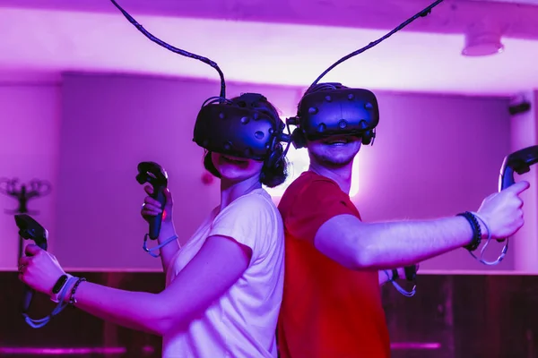 Facet i dziewczyna grają w wirtualną rzeczywistość. Neon pokój gier. — Zdjęcie stockowe