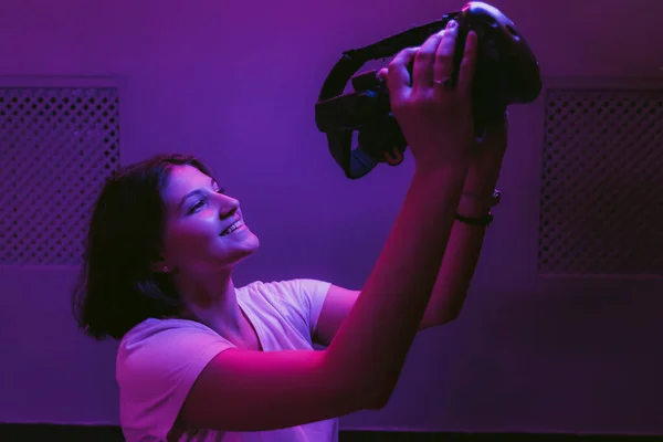 La ragazza si connette alla realtà aumentata. Nuove tecnologie in giochi, film, intrattenimento. Camera al neon. — Foto Stock