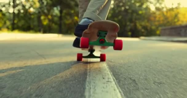 Han gör ett trick på en skateboard, longboard. Utsikt underifrån. — Stockvideo