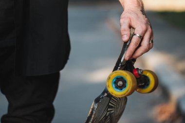 Longboard 'a yakın çekim. Bir erkeğin ellerinde kaymak..