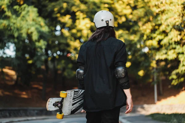 O tipo da administração anda pela rua. Longboarding ao pôr do sol . — Fotografia de Stock