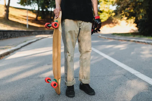 Facet trzyma tablicę z czerwonymi kołami. Skateboarding w wiecznym mieście. — Zdjęcie stockowe