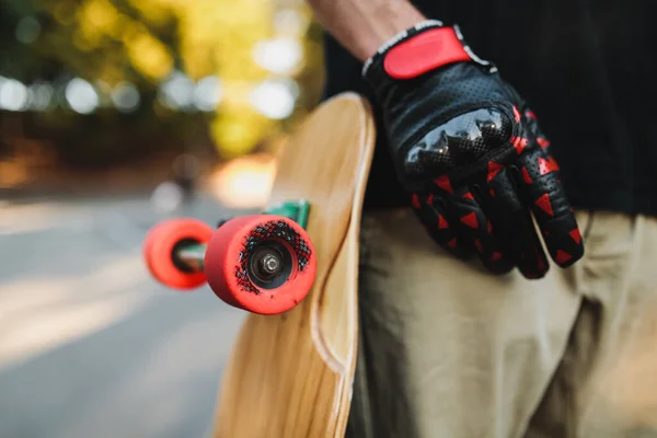 男は赤い車輪の板を持っている。永遠の都でスケートボード. — ストック写真