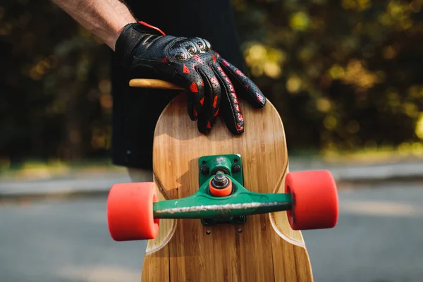 Facet trzyma tablicę z czerwonymi kołami. Skateboarding w wiecznym mieście. — Zdjęcie stockowe