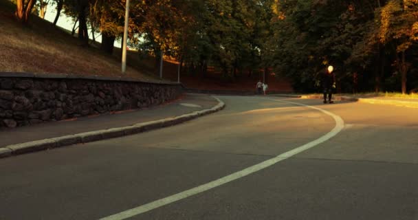 De man bij zonsondergang rijdt op een skateboard. — Stockvideo