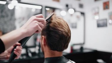 Erkek saçının kurutulması ve şekillendirilmesi. Yavaş çekim.