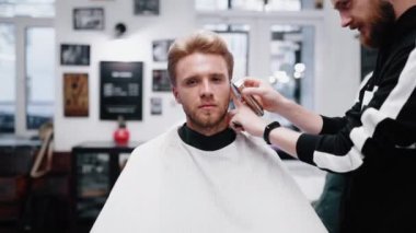 Kuaför müşteriye şık bir saç kesimi yapar. Kameraya vuruyorum..