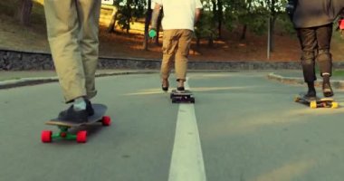 Çocukların şirketi sonsuz karanlık şehirde paten kayıyor. Gün batımında sörf tahtası.