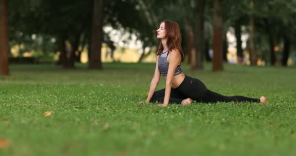 Hermosa chica entra a los deportes en el parque en el césped. Meditación en la naturaleza. — Vídeos de Stock