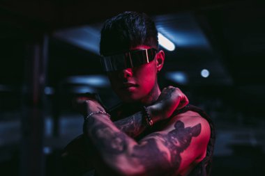 Gece şehrindeki adam. Neon bir şehirde Asyalı görünümlü bir adamın portresi.