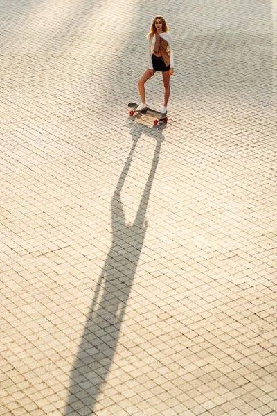 A woman skates in the evening city. — Stock Photo, Image