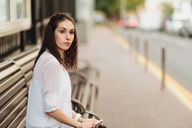 Genç ve güzel bir bayan durakta otobüs bekliyor..
