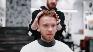 Erkek saç kesimi ve saç kesimi. Berber müşterinin isteklerini yerine getirir..