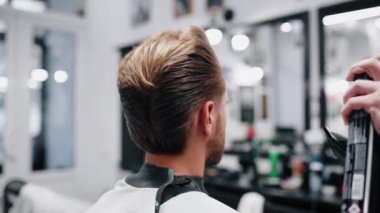 Saç spreyiyle saçımı düzeltiyorum. Yavaş çekim.