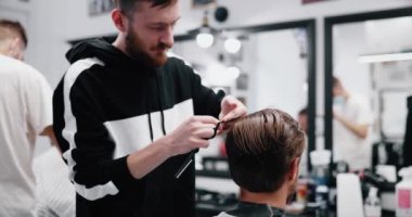 Erkek saçının kurutulması ve şekillendirilmesi. Yavaş çekim.