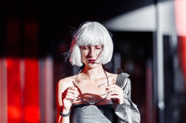 Şık elbiseli, kırmızı arka planda sarışın..