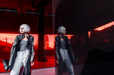 Kırmızı arka planda, şık elbiseli bir sarışın. siber punk stili 