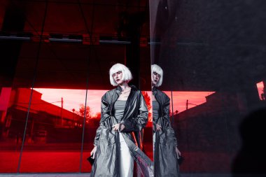 Kırmızı arka planda, şık elbiseli bir sarışın. siber punk stili 